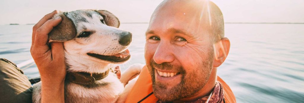 A dog pictured with its owner in the ocean