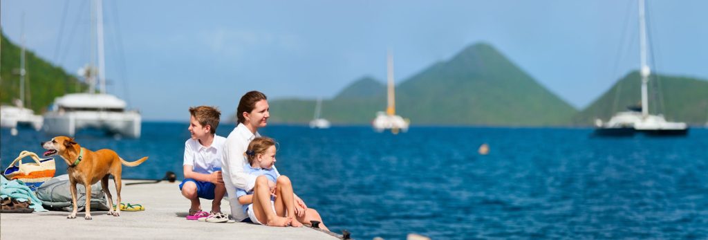 A family and their dog photographed next to the ocean.