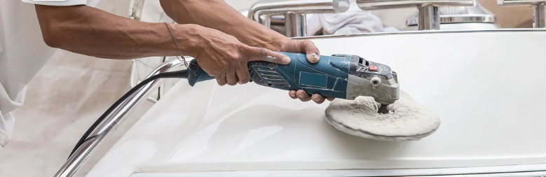 An individual cleaning the exterior of a yacht